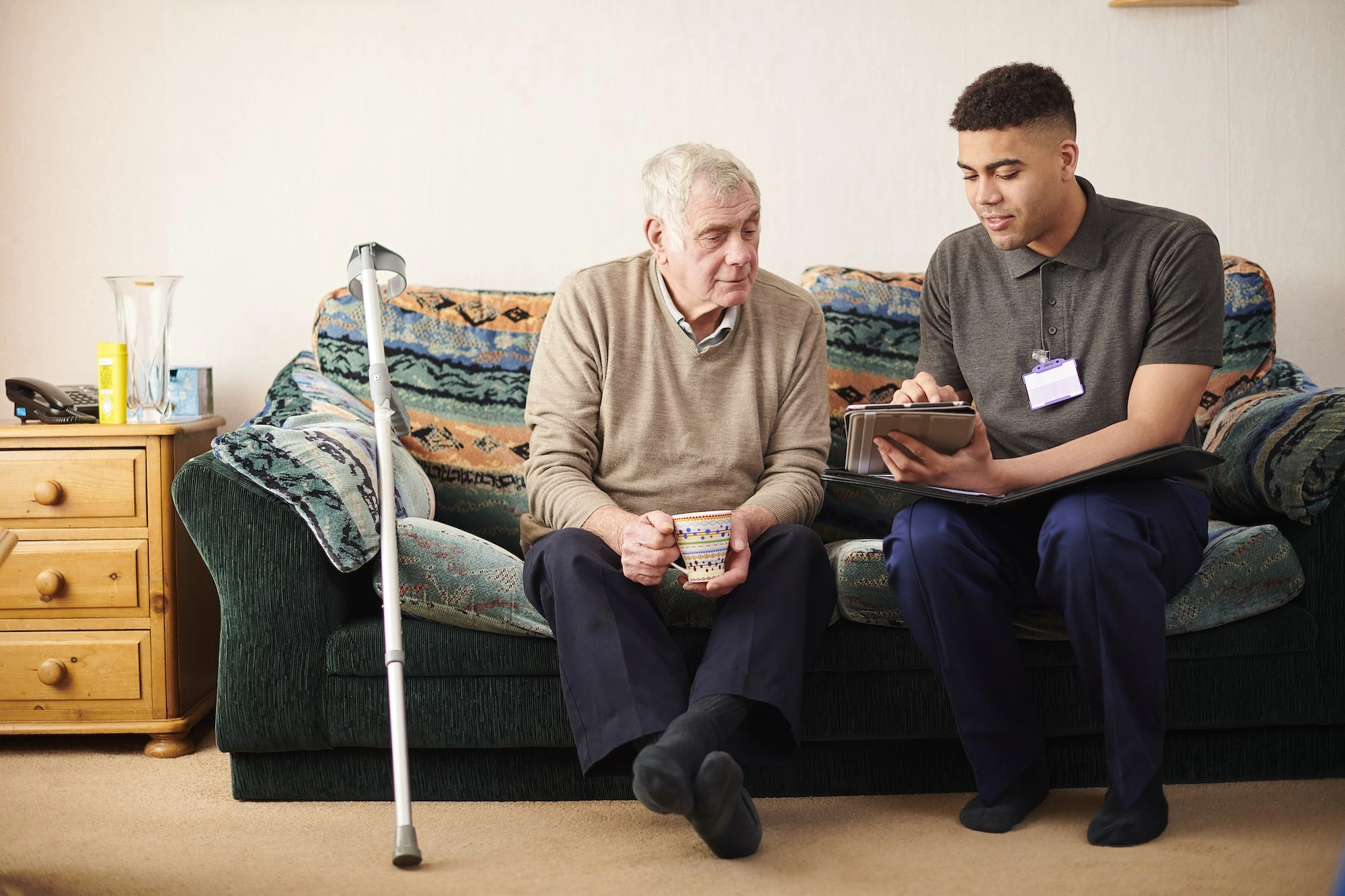 Photograph of a social worker speaking with an elderly man.